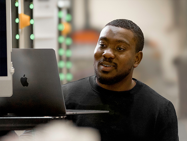 An Apple Operations and Supply Chain team member working on a MacBook.