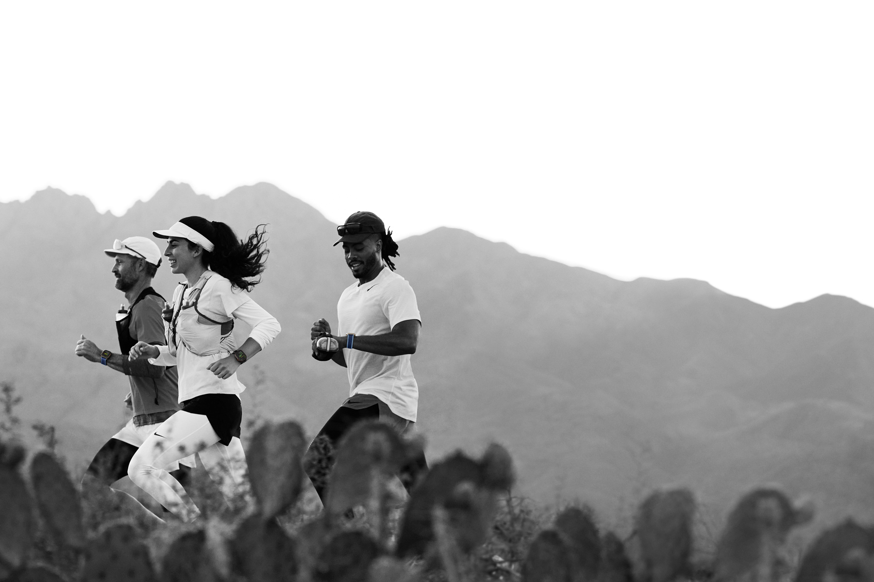 Osoby biegnące pustynnym szlakiem monitorują swój trening na Apple Watch Ultra 3