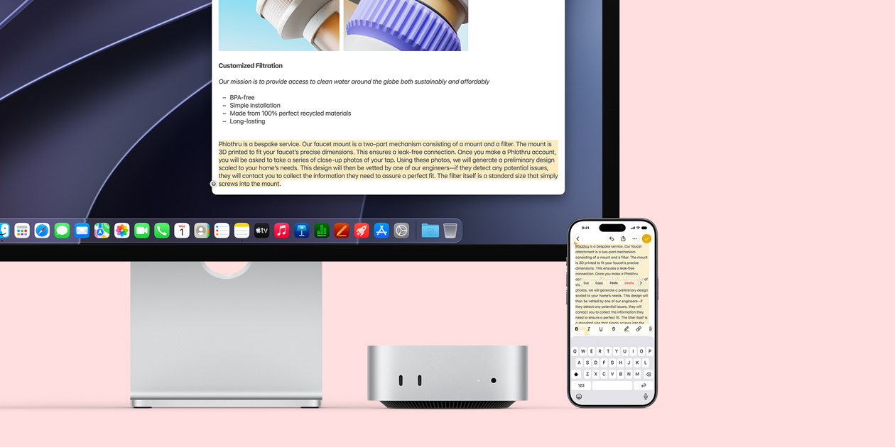 Widok z przodu na Maca mini wsuniętego pod monitor Studio Display, po prawej stronie urządzenia znajduje się iPhone; na ekranie iPhona widać zaznaczony tekst z opcjami wklejenia, kopiowania i wklejania oraz poleceniem automatycznego uzupełniania, które pasują do wyróżnionego tekstu na wyświetlaczu, prezentując Uniwersalny schowek