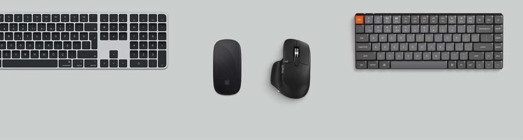 Mac mini, Studio Display, kablosuz klavyeler, kablosuz mouse’lar, bir oyun kumandası ve AirPods Max’in bulunduğu masa düzeninin üstten görünümü