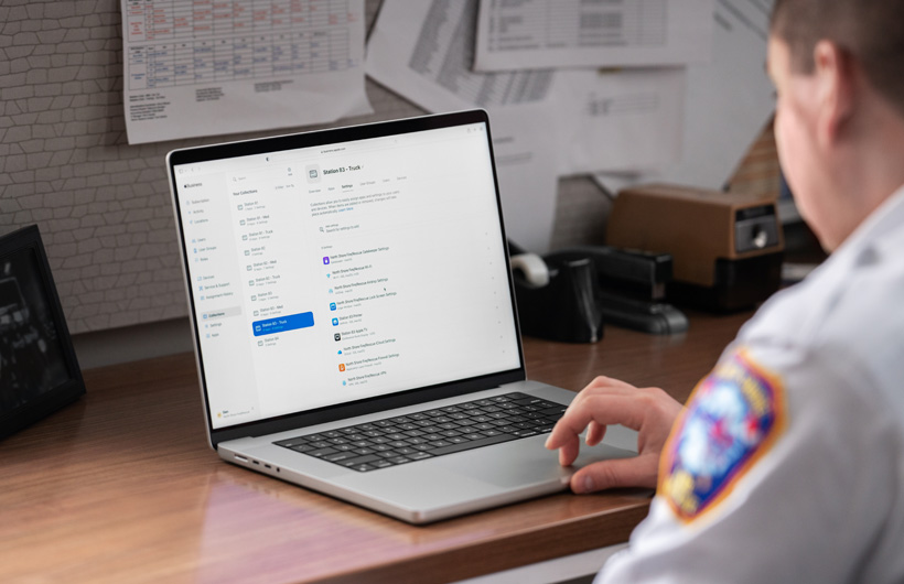 Eine Führungskraft im Büro benützt ein MacBook mit Apple Business Essentials auf dem Bildschirm