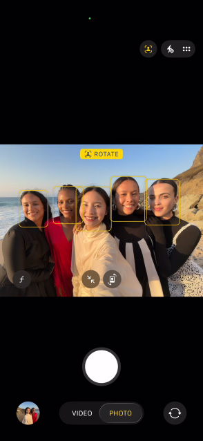 Ekran iPhone’a Air, na nim grupowe selfie w apce Zdjęcia z włączoną funkcją Centrum uwagi