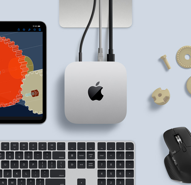 Sidabro spalvos „Mac mini“ ant darbo stalo su juodos ir sidabrinės spalvos belaide klaviatūra, juoda belaide pele ir „iPad“, vaizdas iš viršaus